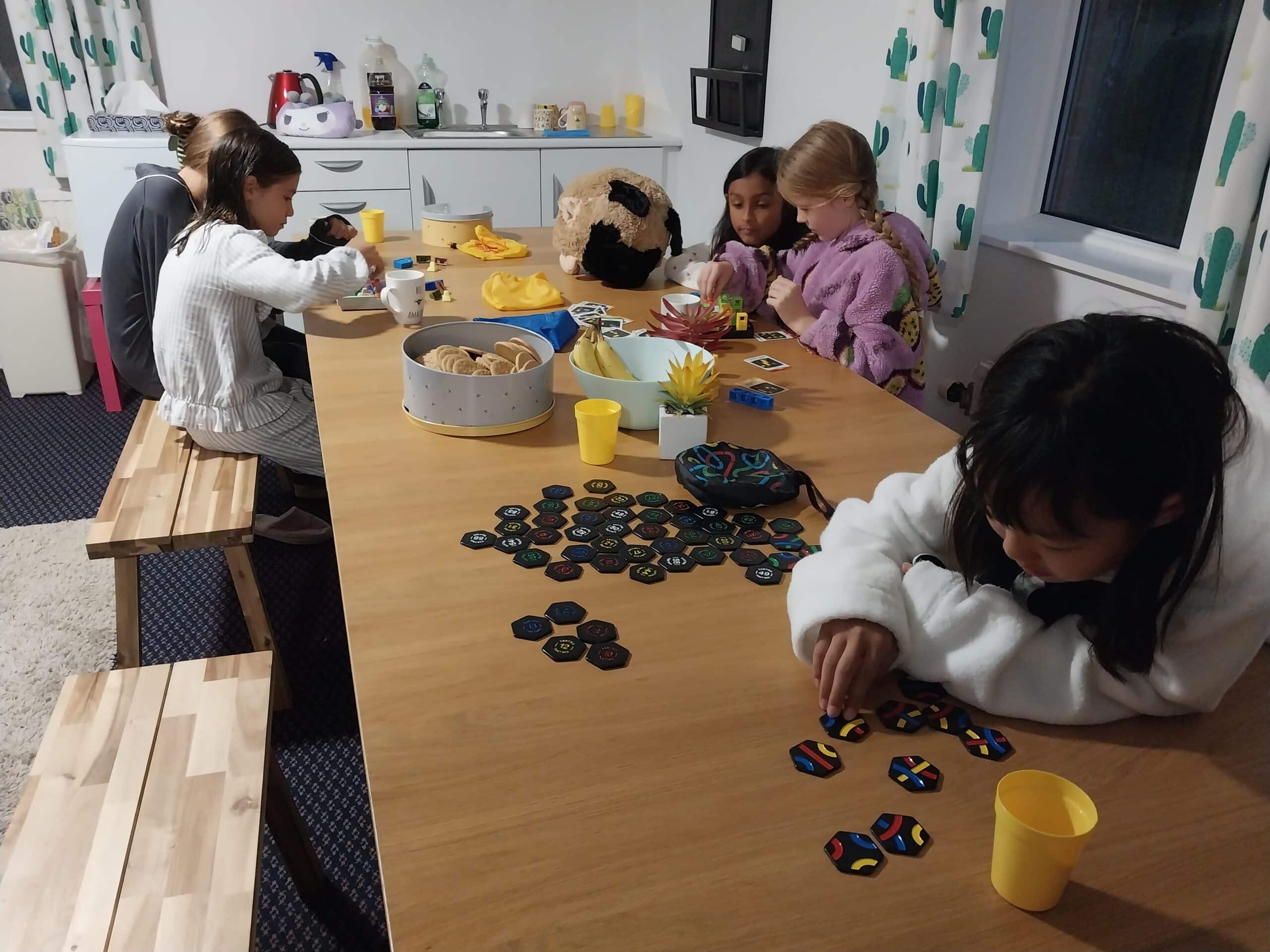 Group of girls enjoying playing games around a table