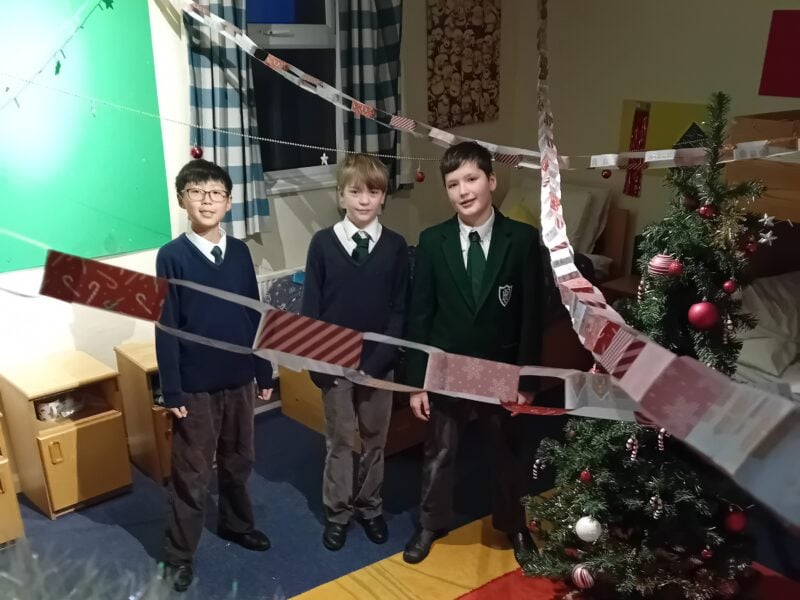 Boys in school uniform surrounded by Christmas decorations