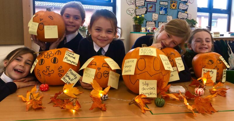 Group of girls creating art with pumpkins