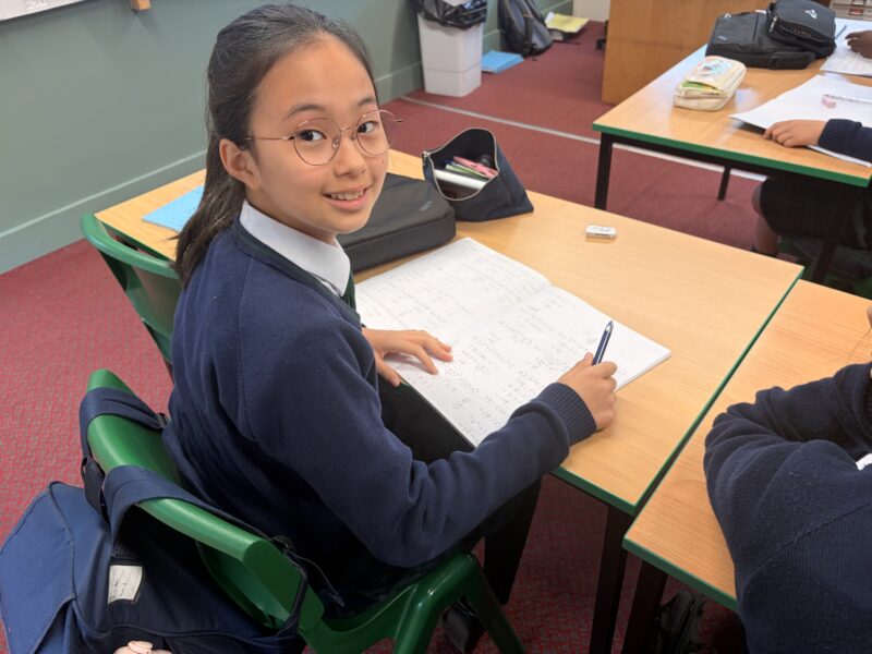 Girl working on maths sums in classroom