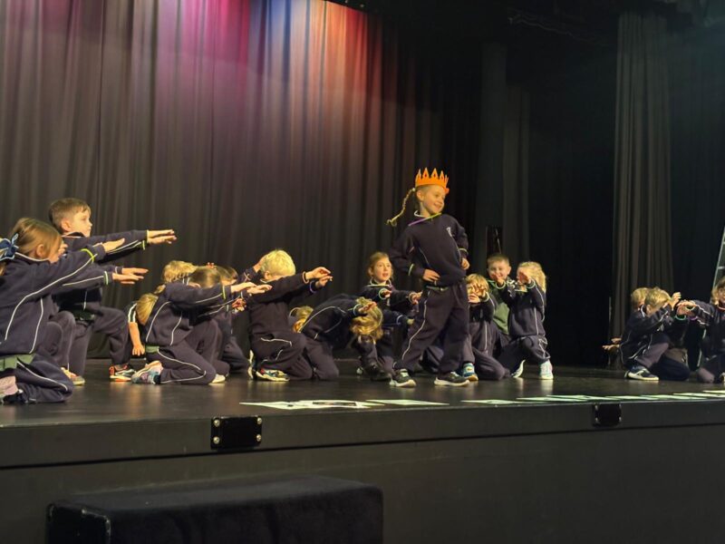 Young children performing energetically on stage