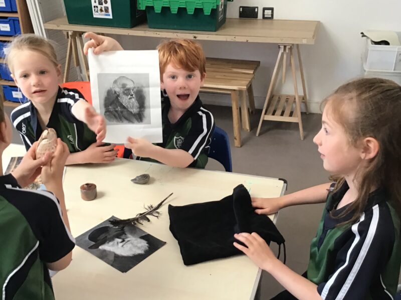 Young boys and girls with a picture of Charles Darwin