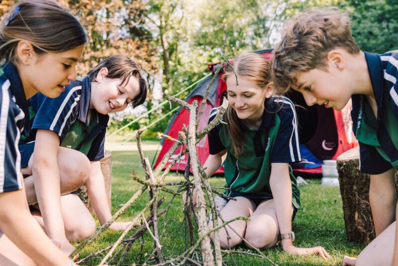 Four children learning camping skills
