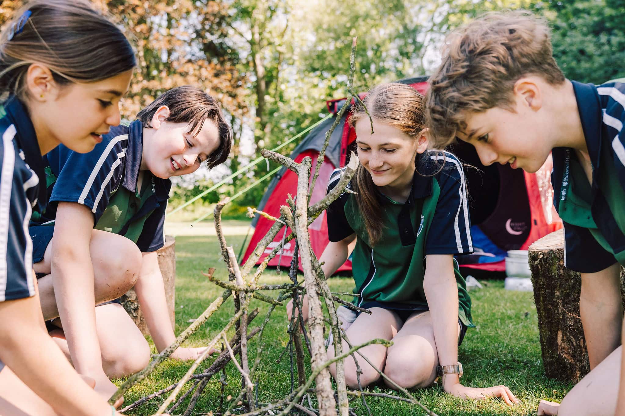 Four children learning camping skills