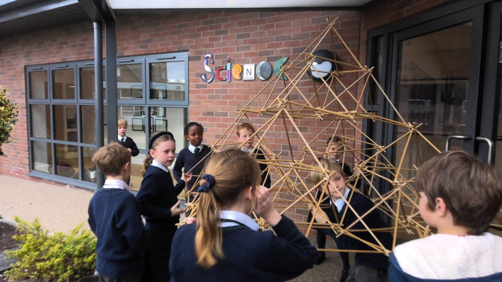Children creating a structure using bamboo