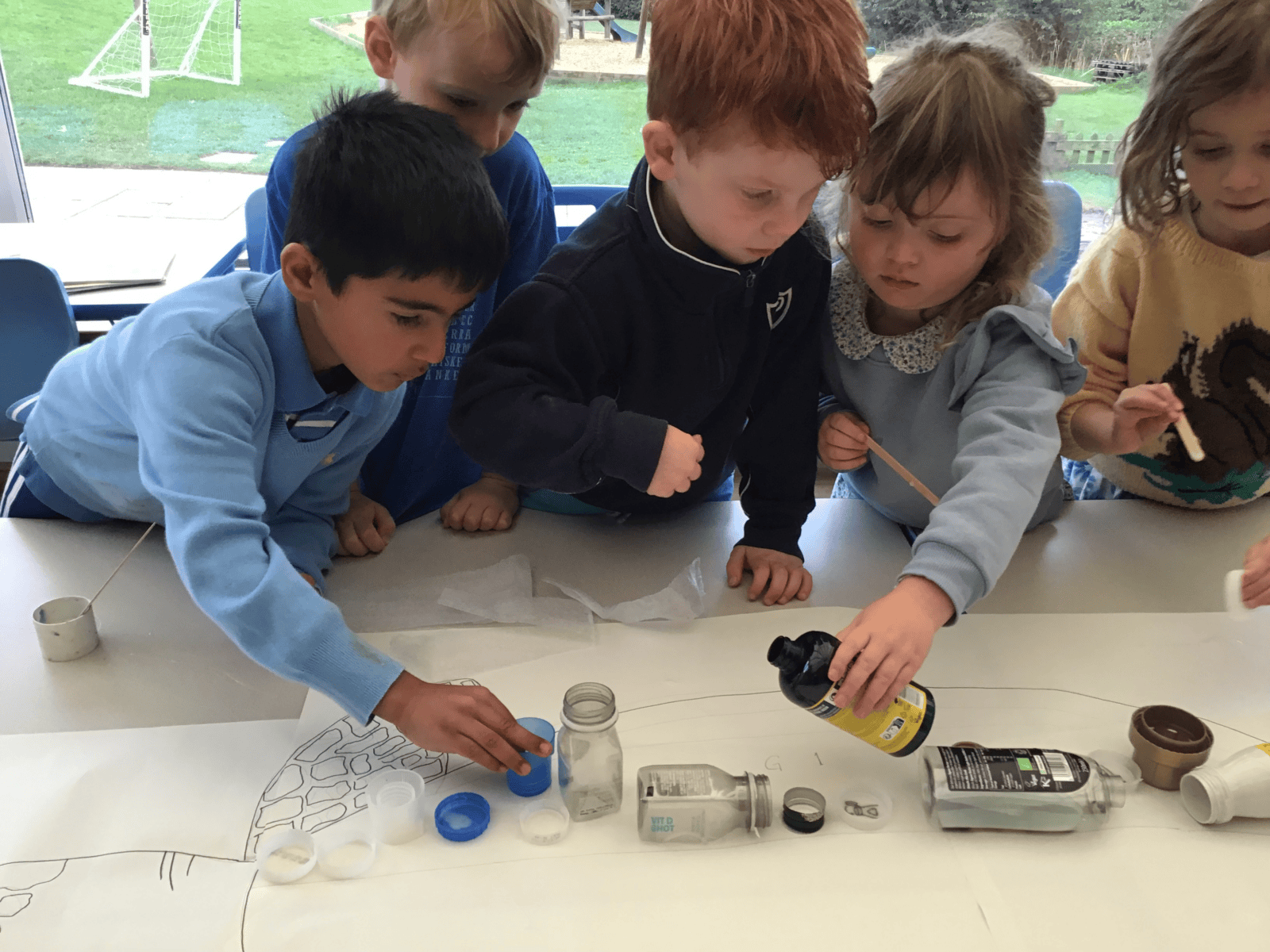 Young children looking at ocean life project