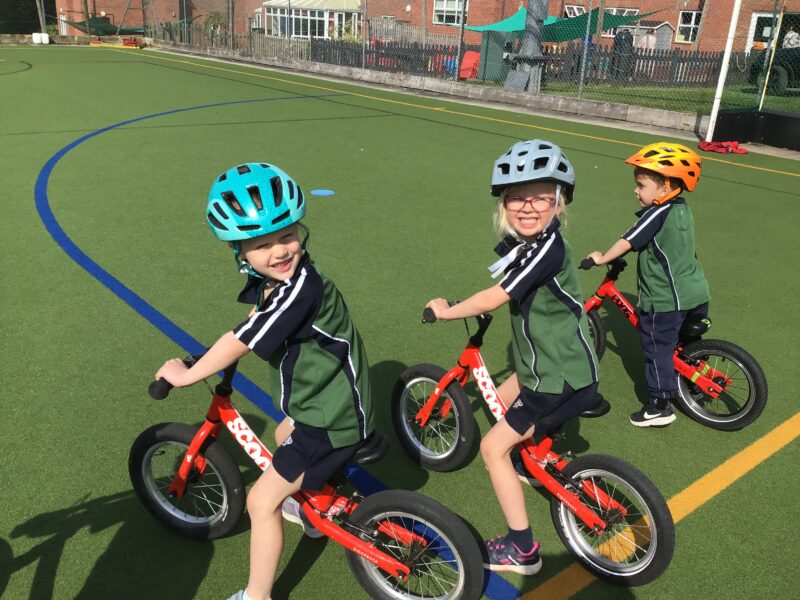 Three children with helmets on bikes