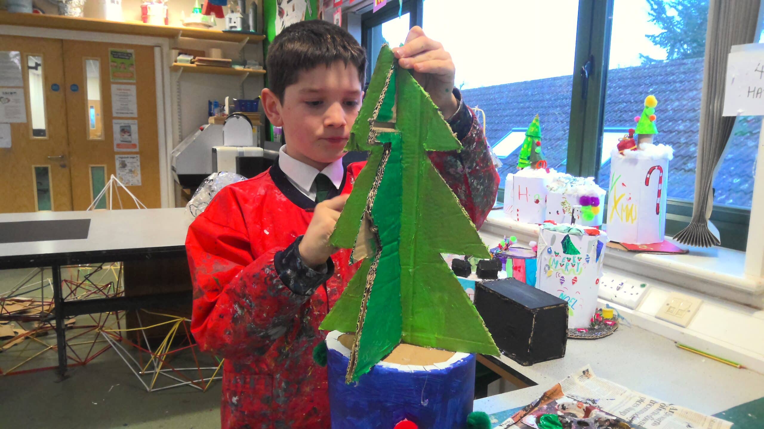 Boy creating a Christmas hat in a design lesson