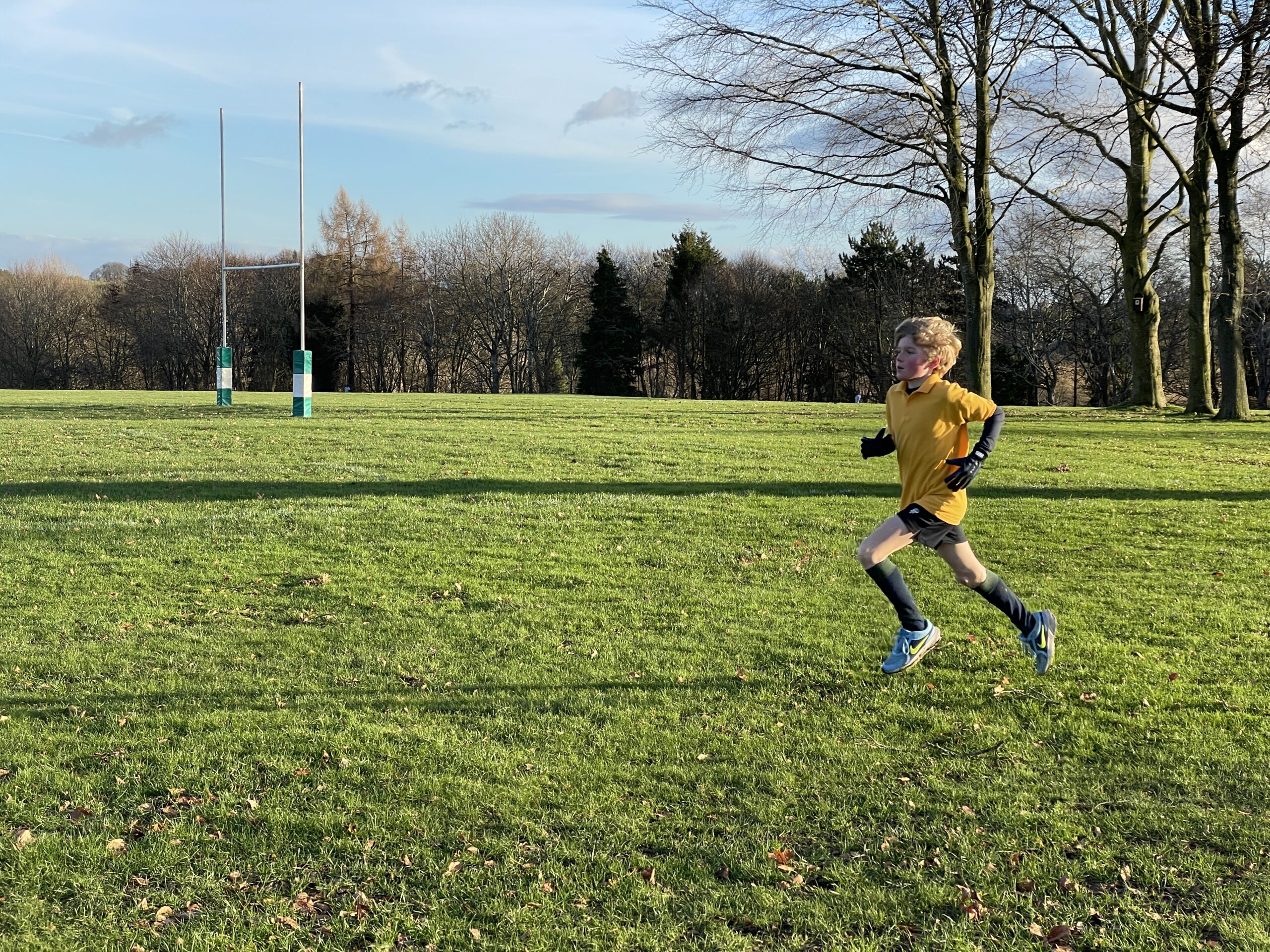 Boy running cross country race in school field