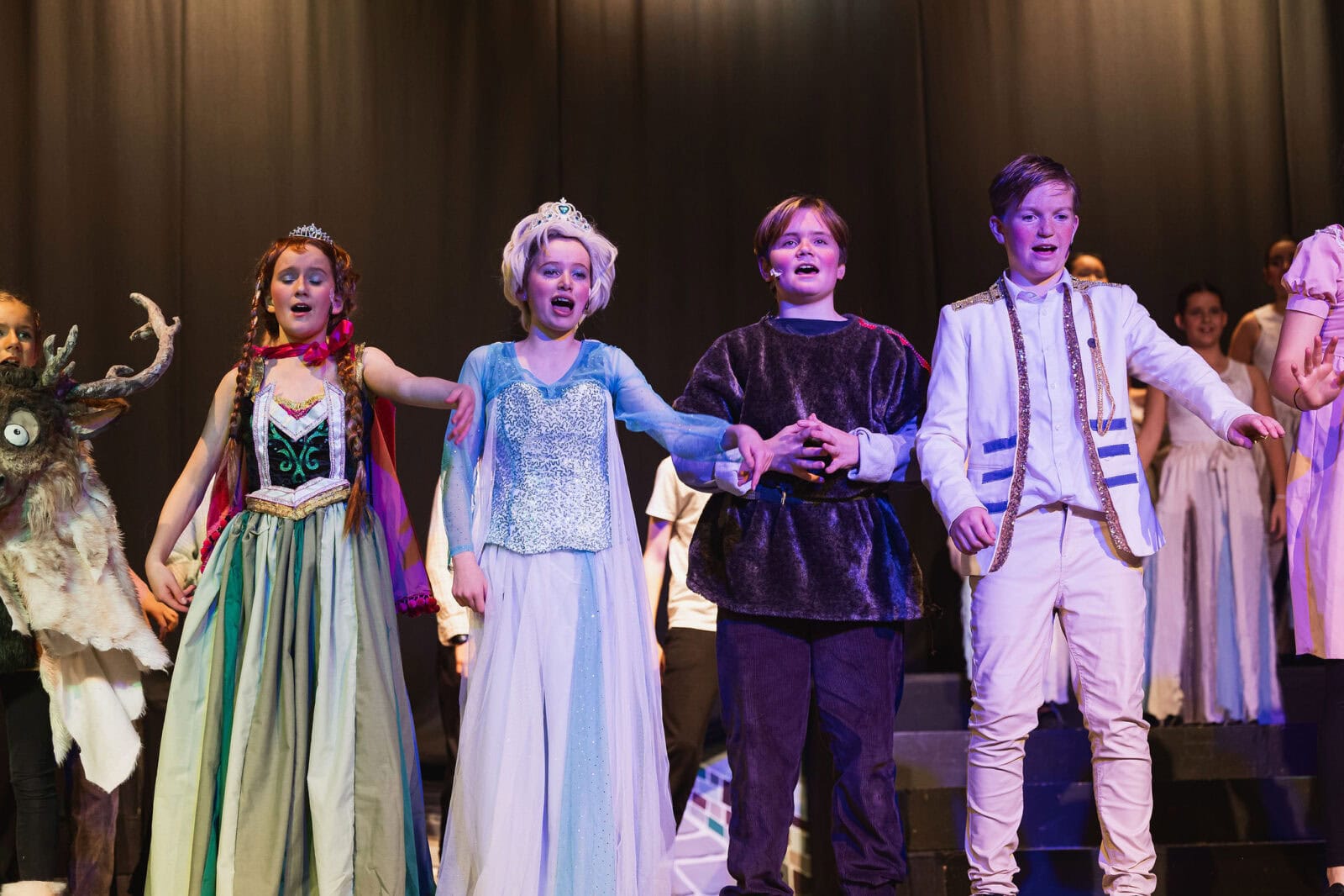 Four children performing on theatre stage