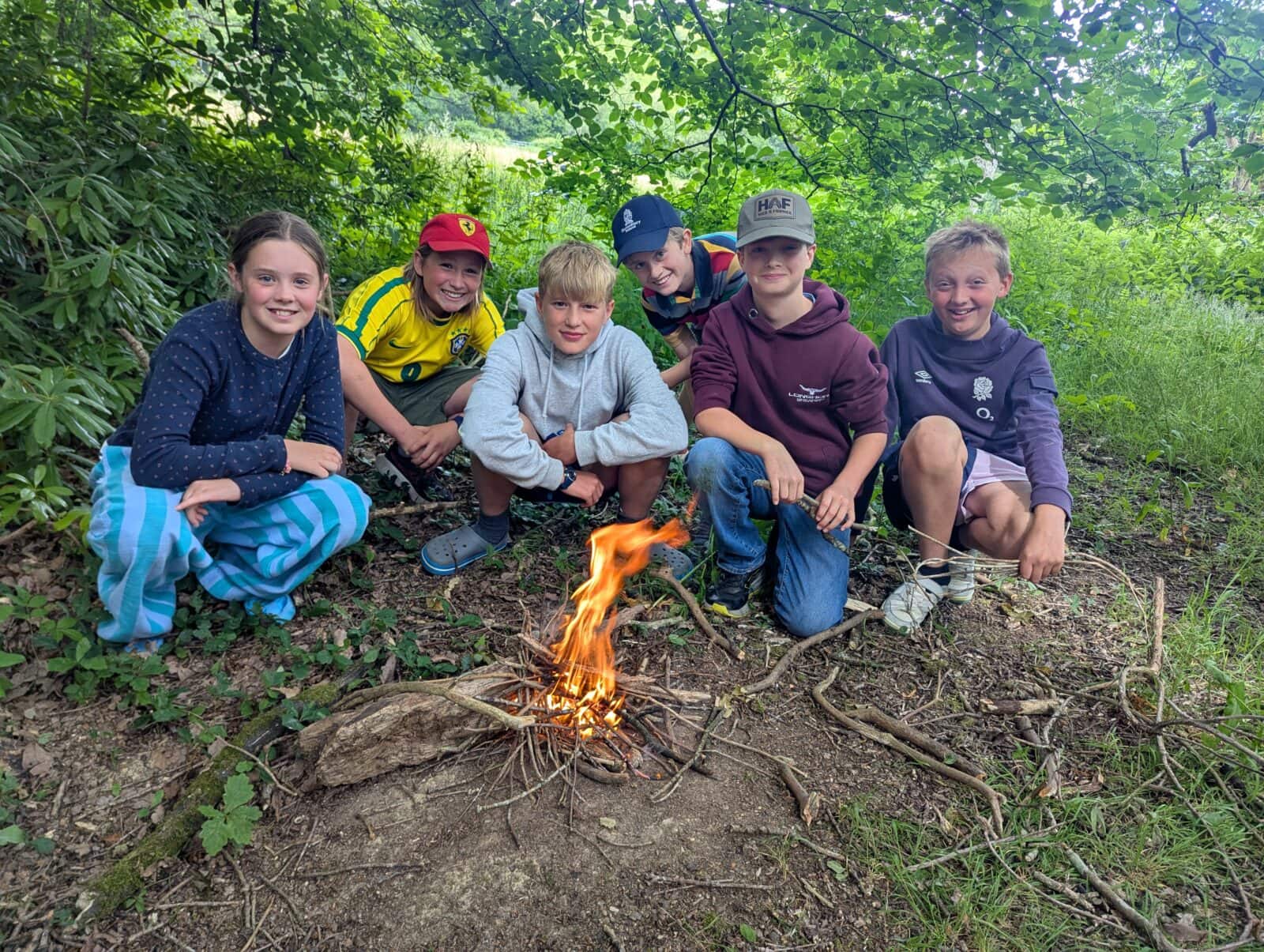 Group of girls and boys sat around a campfire