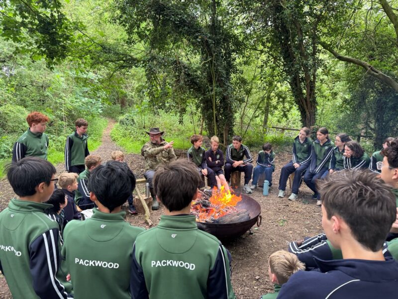 School children sat around campfire in Packwood jumpers