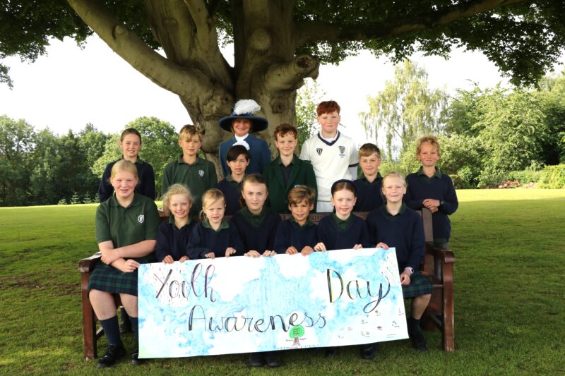 Group of chidlren with the High Sheriff of Shropshire and a Youth Awareness poster