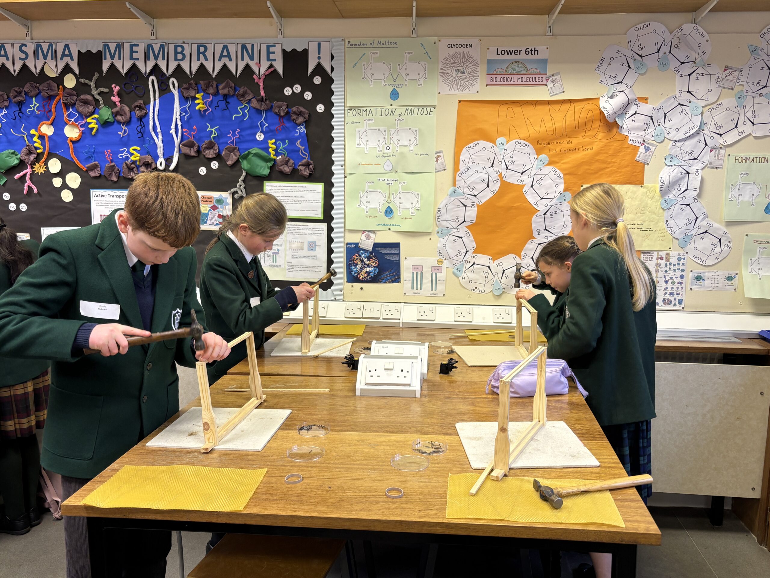Children creating wooden frames in classroom