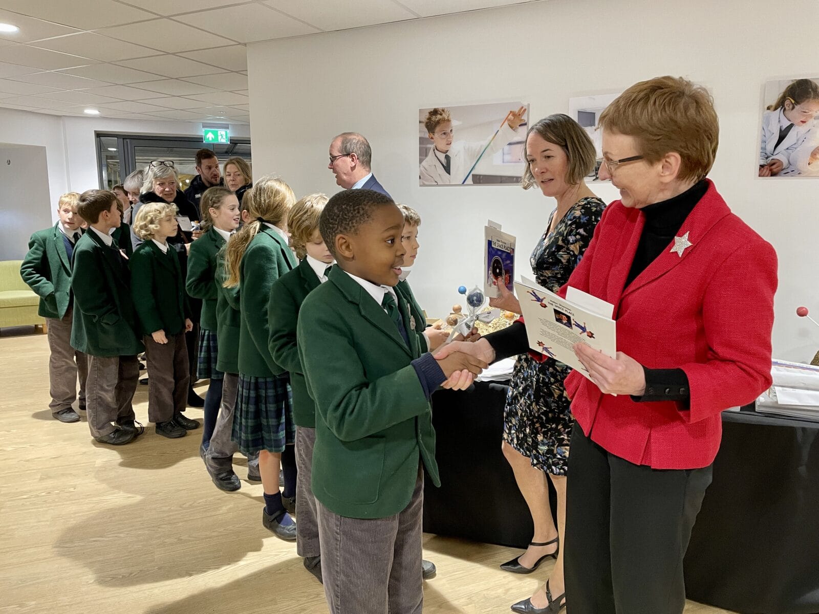 Pupils being presented with a science book for the opening of school science centre