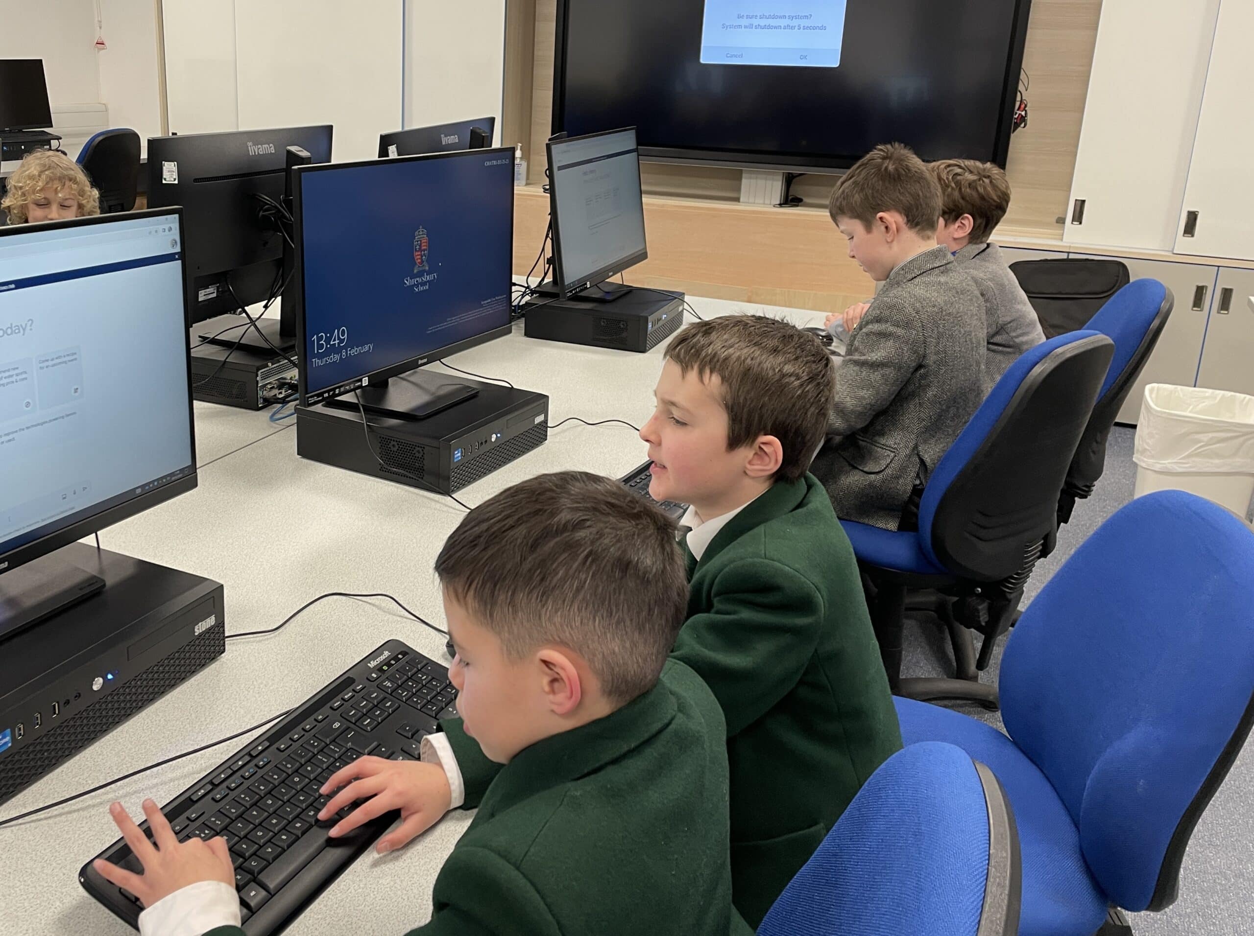 Two boys working together at a computer screen