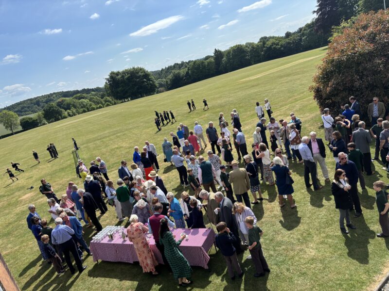 Aerial view of a group of people gathered for a garden party on a sunny day