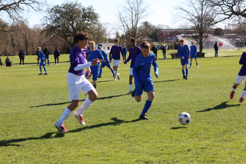 Boys playing football match on a sunny day