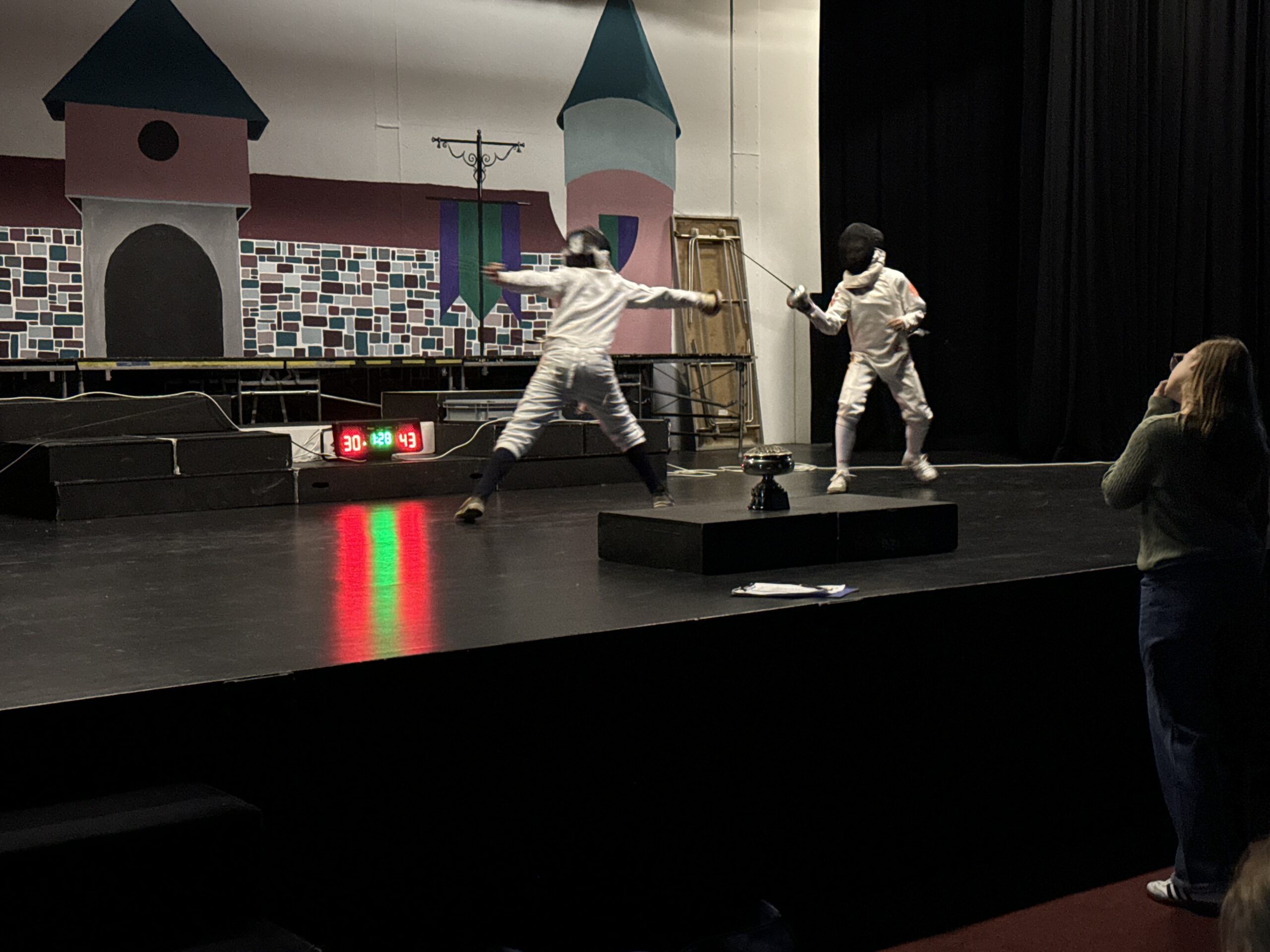 Two pupils competing in a school fencing competition