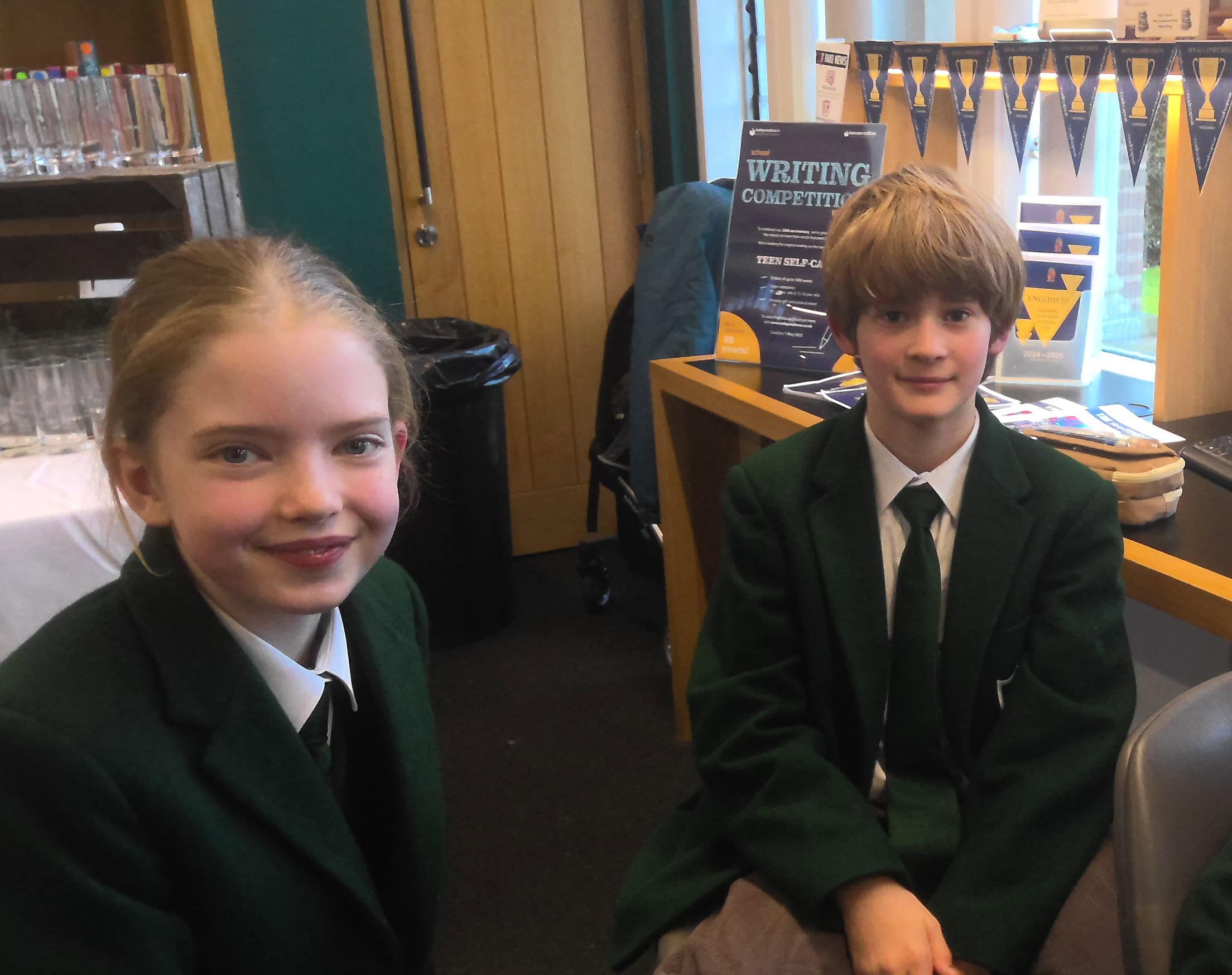 Two happy, smiling pupils in school library