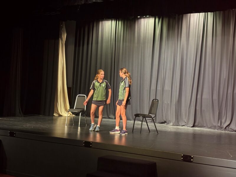 Two girls performing on school stage