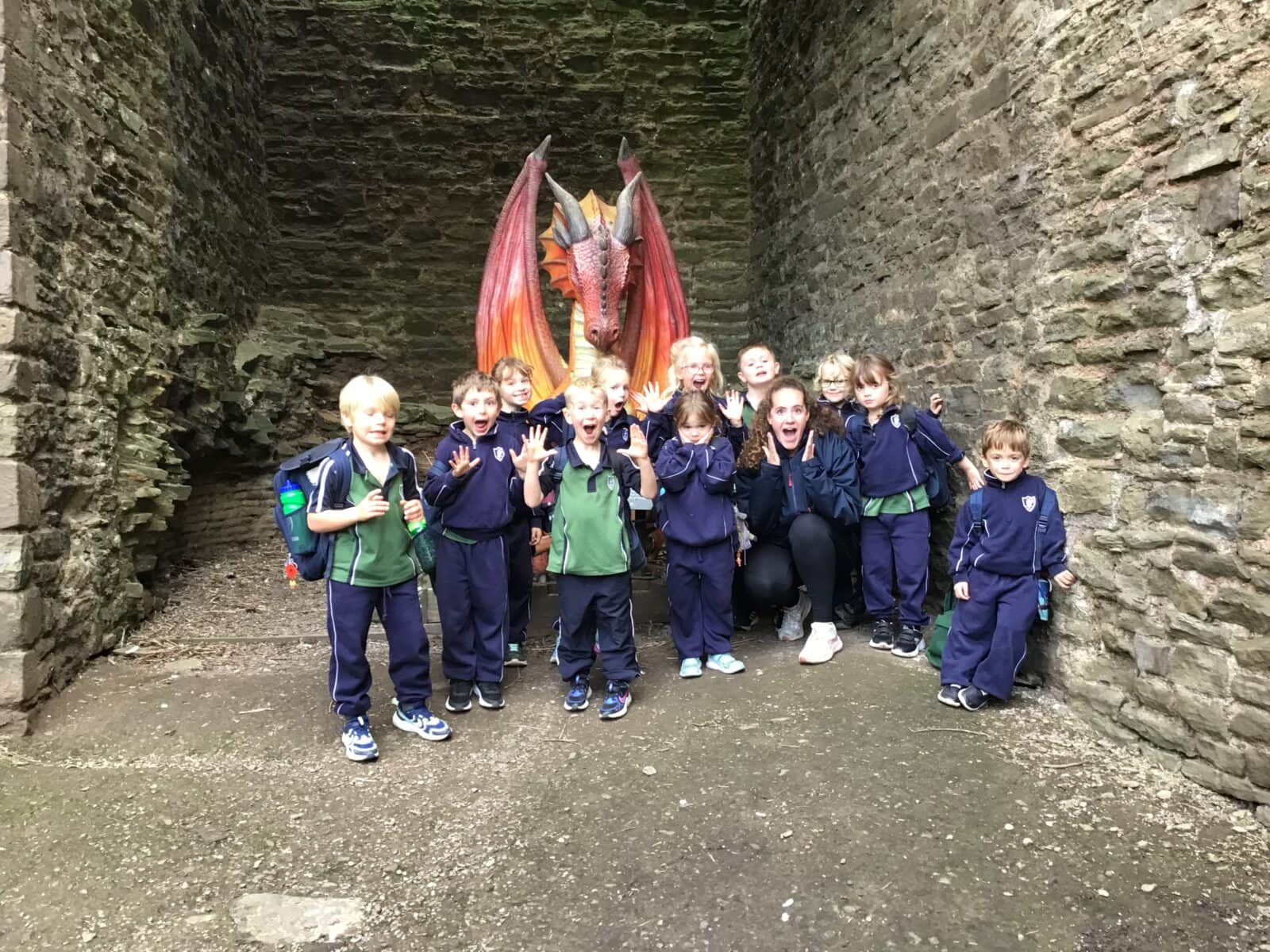 Group of school children by a dragon statue at Ludlow Castle