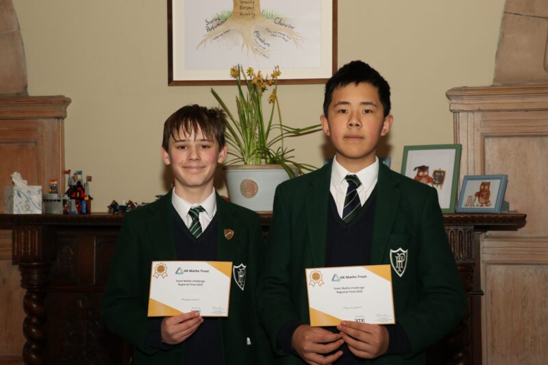 Two boys holding certificates for a maths competition