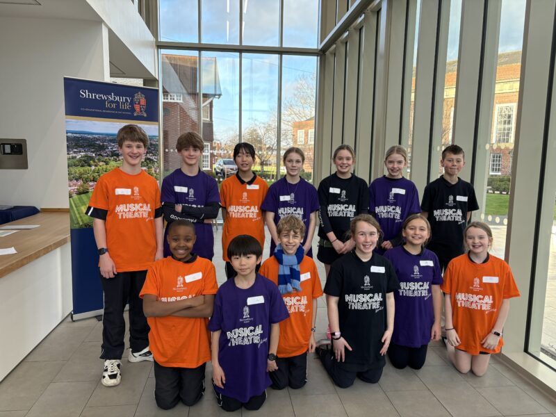 Group of children in brightly coloured musical theatre t-shirts