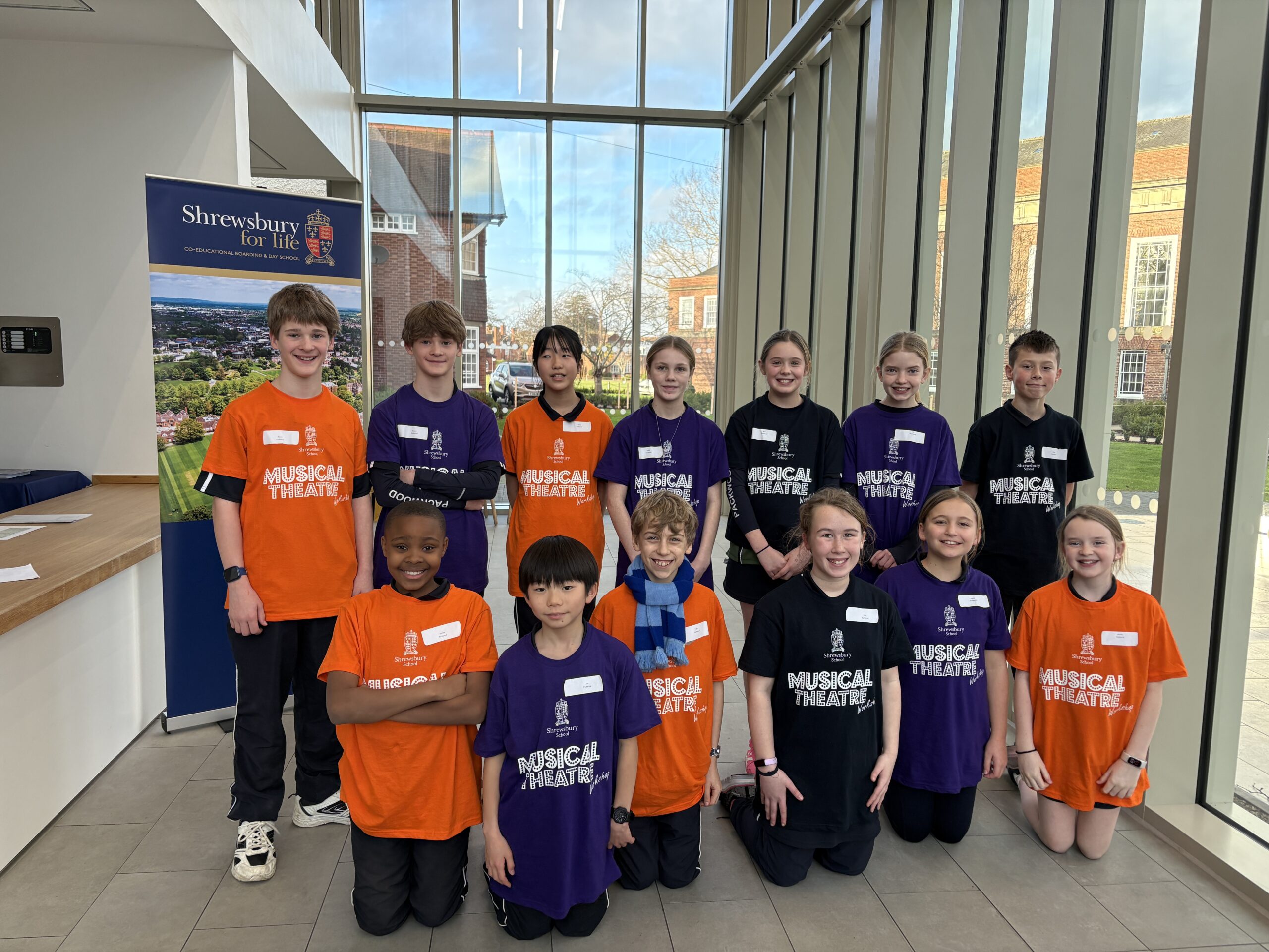Group of children in brightly coloured musical theatre t-shirts