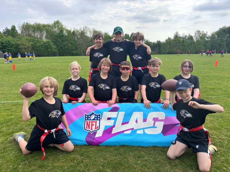 Children in team kit and NFL Flag Football banner