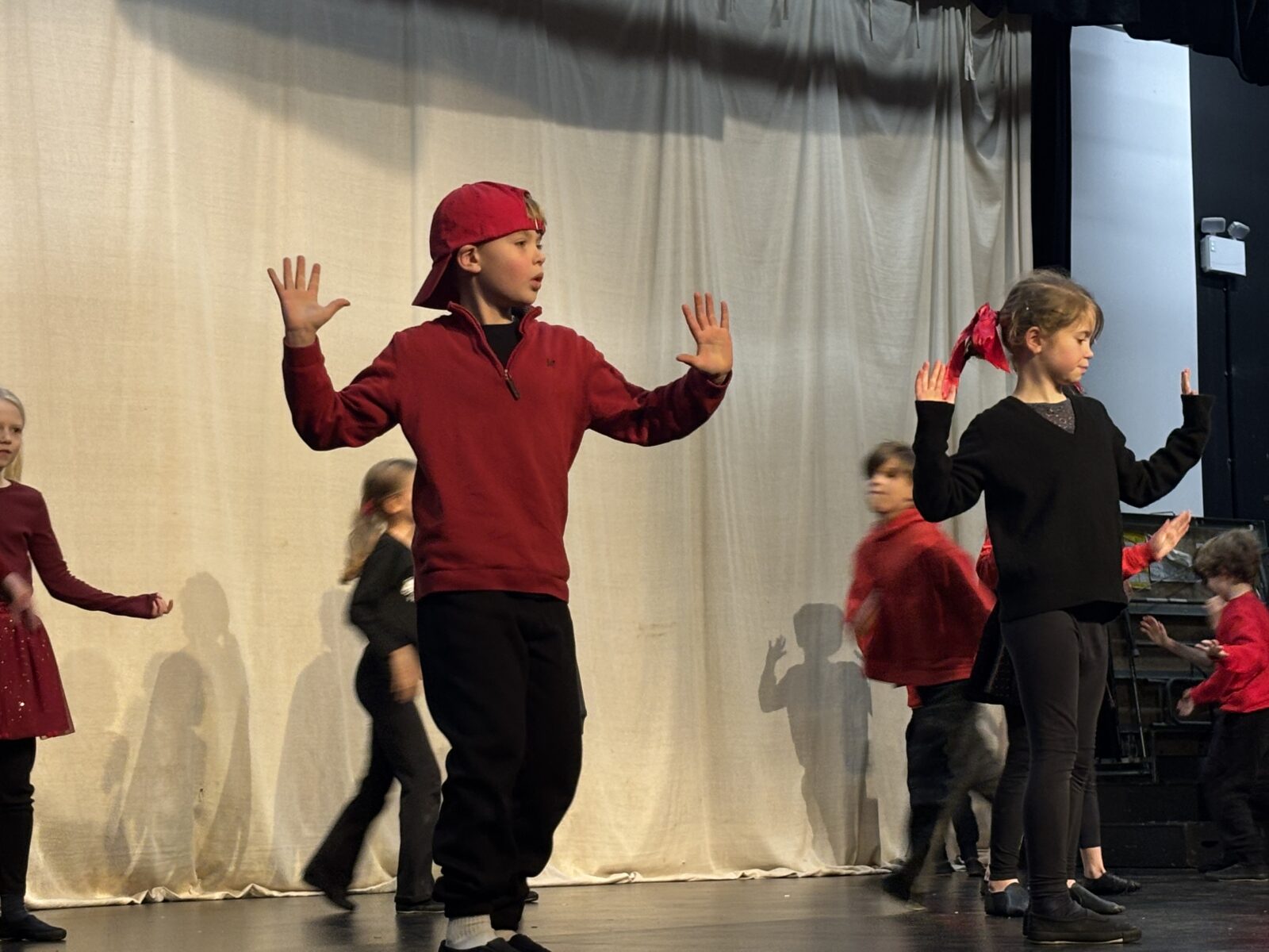 Young girl and boy performing dance routine on school stage