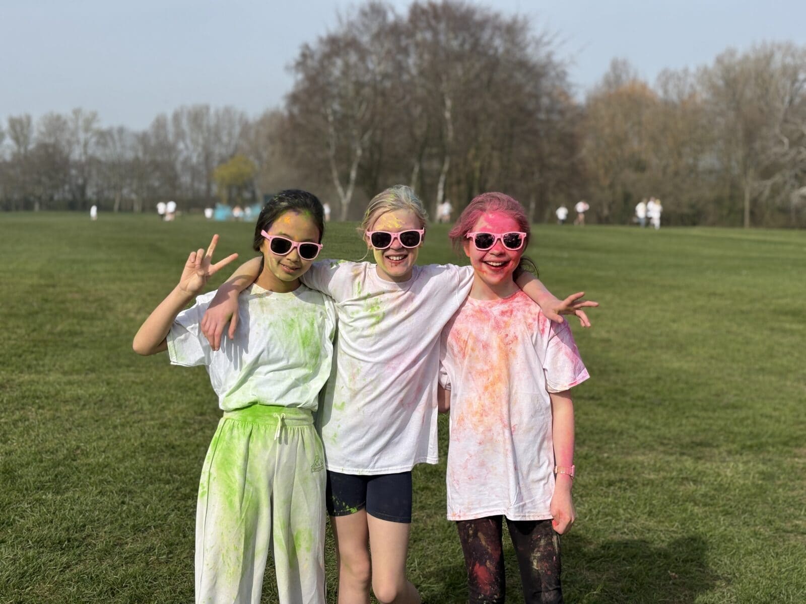 Three girls taking part in colour run