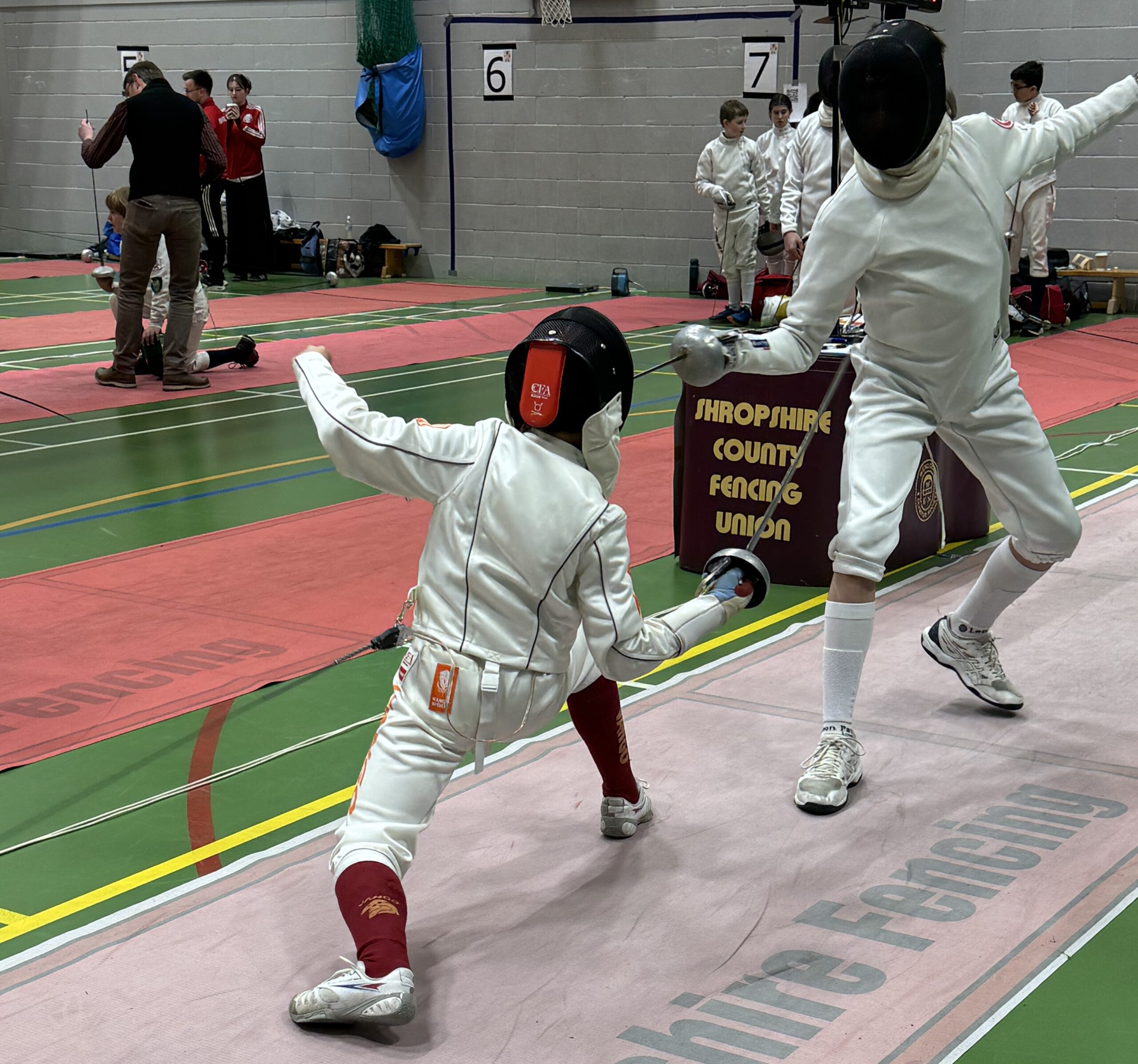 Two children fencing in full fencing gear