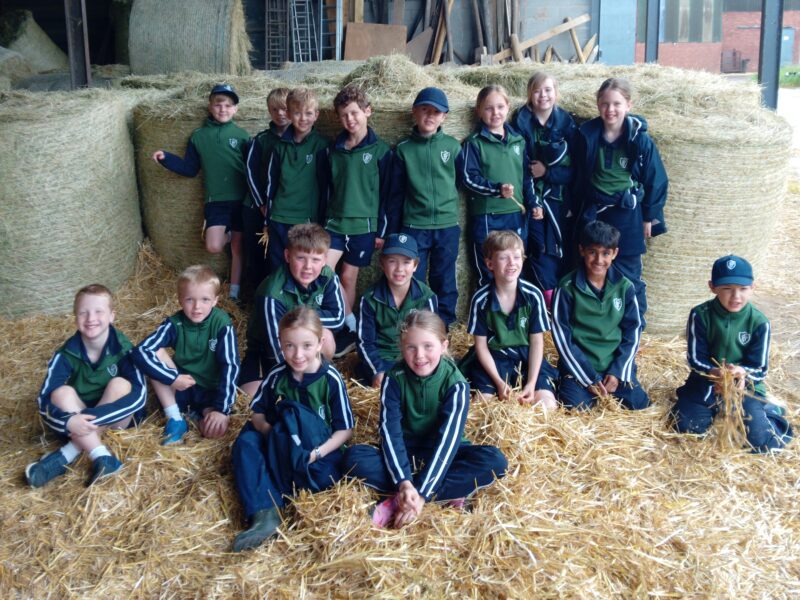 Group of children in Packwood School sports kit on a trip to a farm