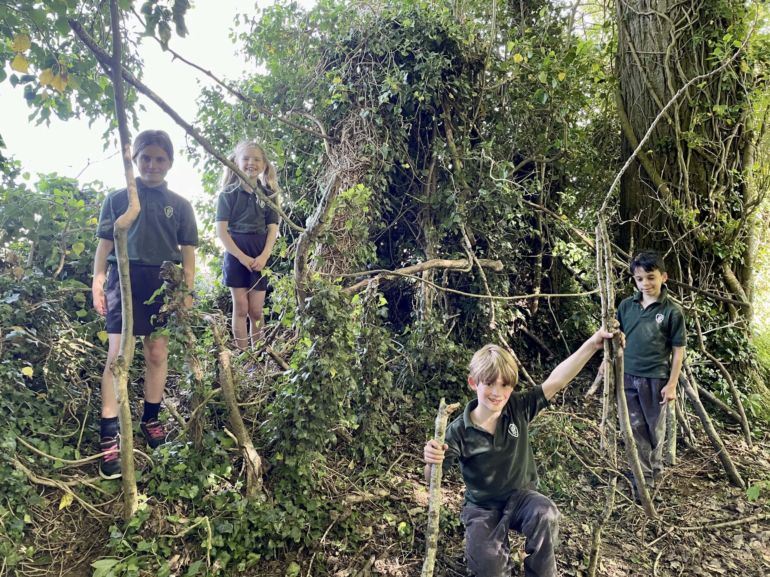 Children den building and exploring school grounds