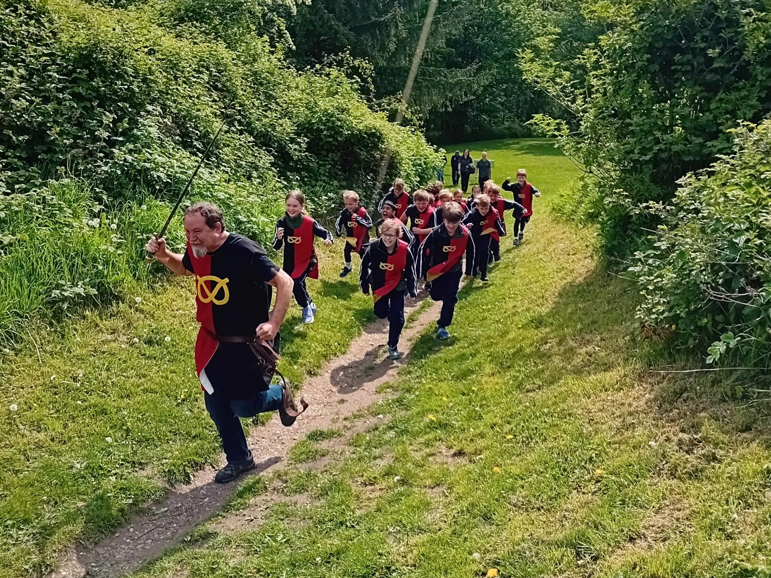 Pupils in a history reenactment running through castle grounds