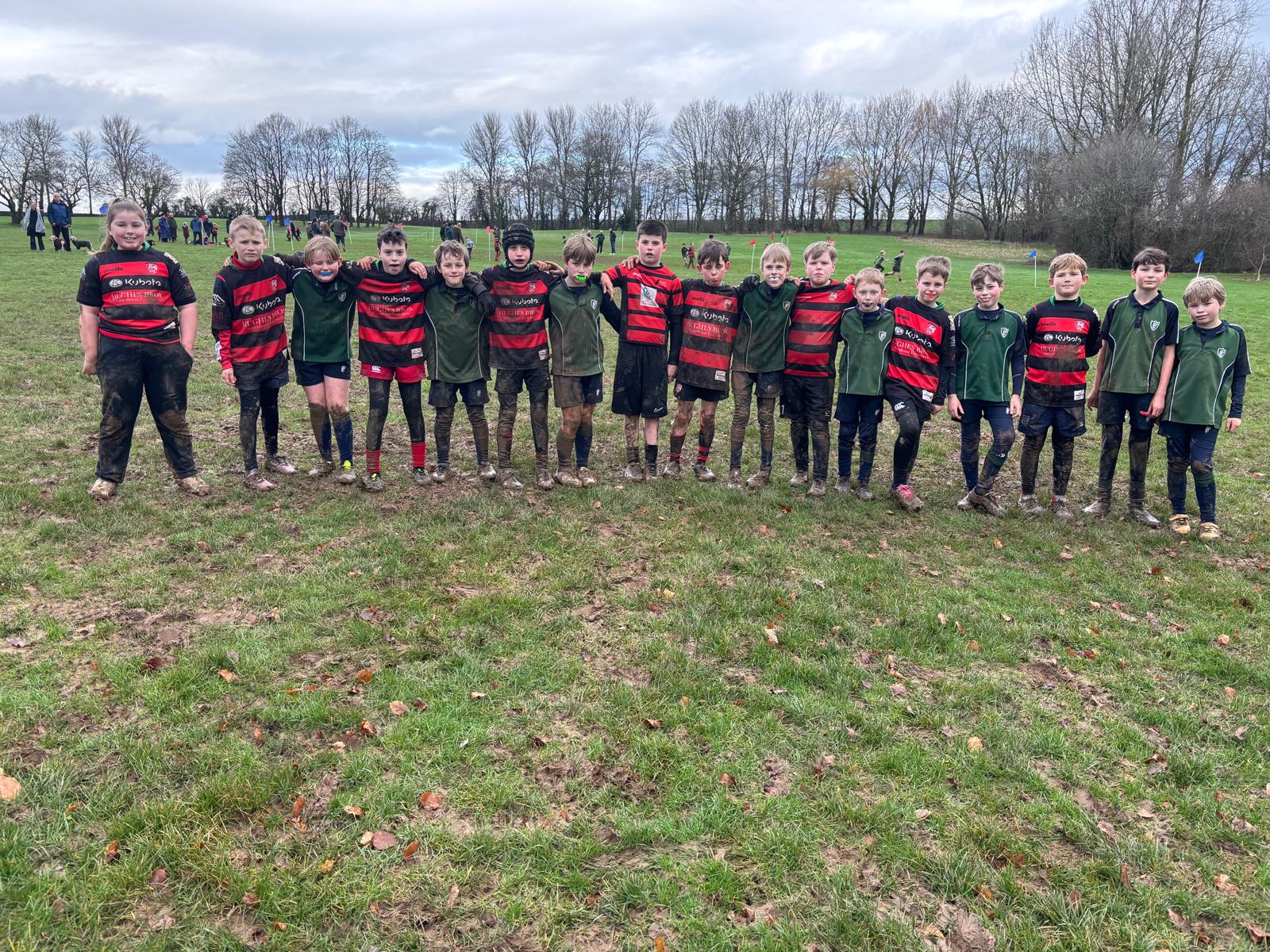 Two rugby teams in a muddy field