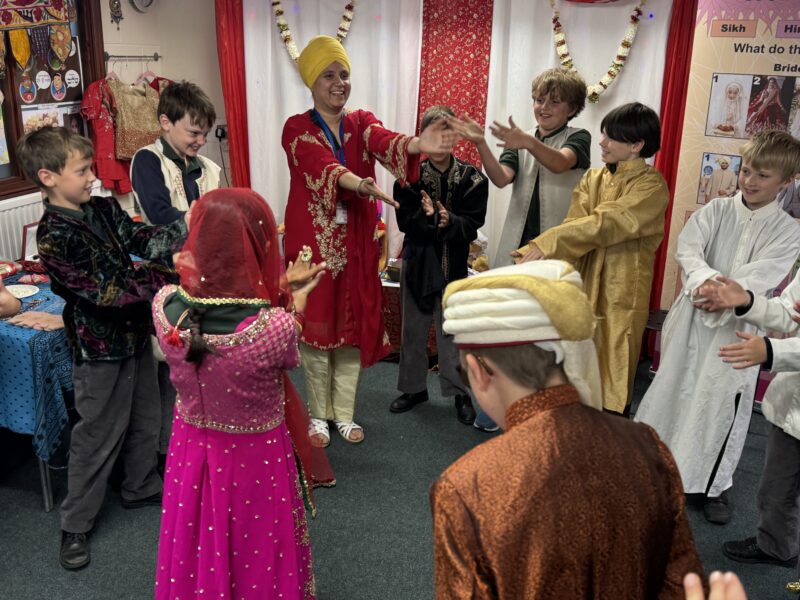 Group of children on school trip learning about different faiths