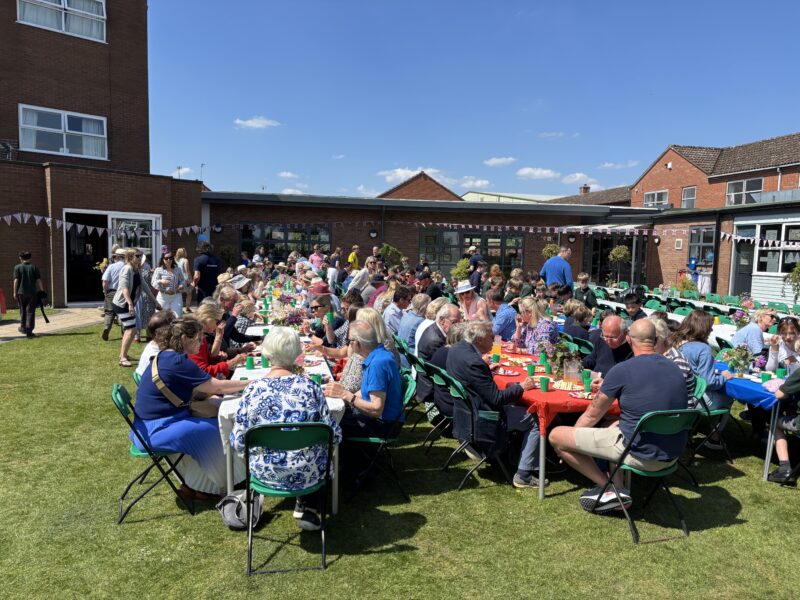 Large group of people enjoying lunch in the sunshine
