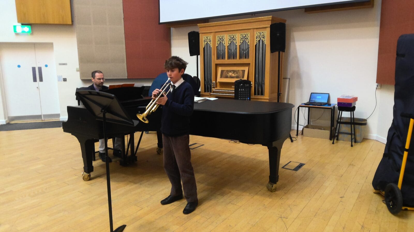 Boy playing trumpet in a music hall