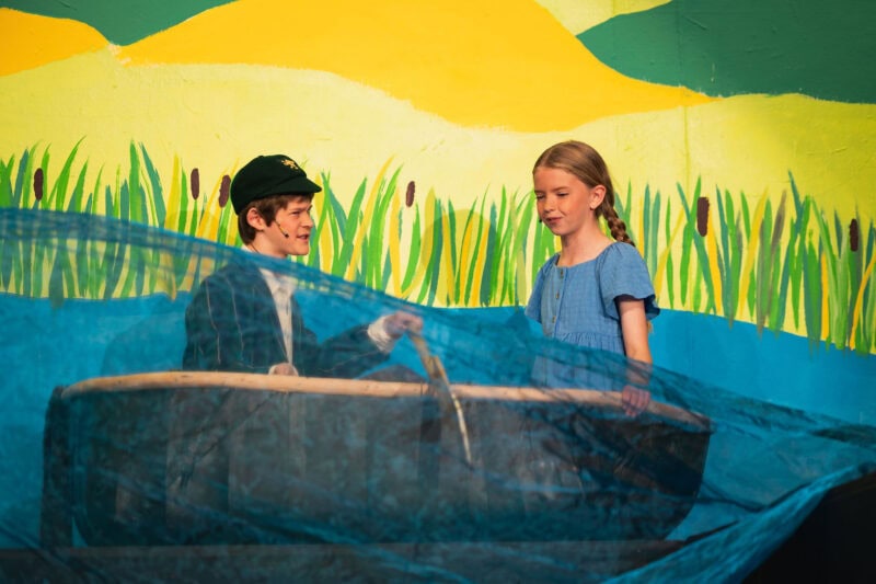 Girl and boy in a boat on a school stage