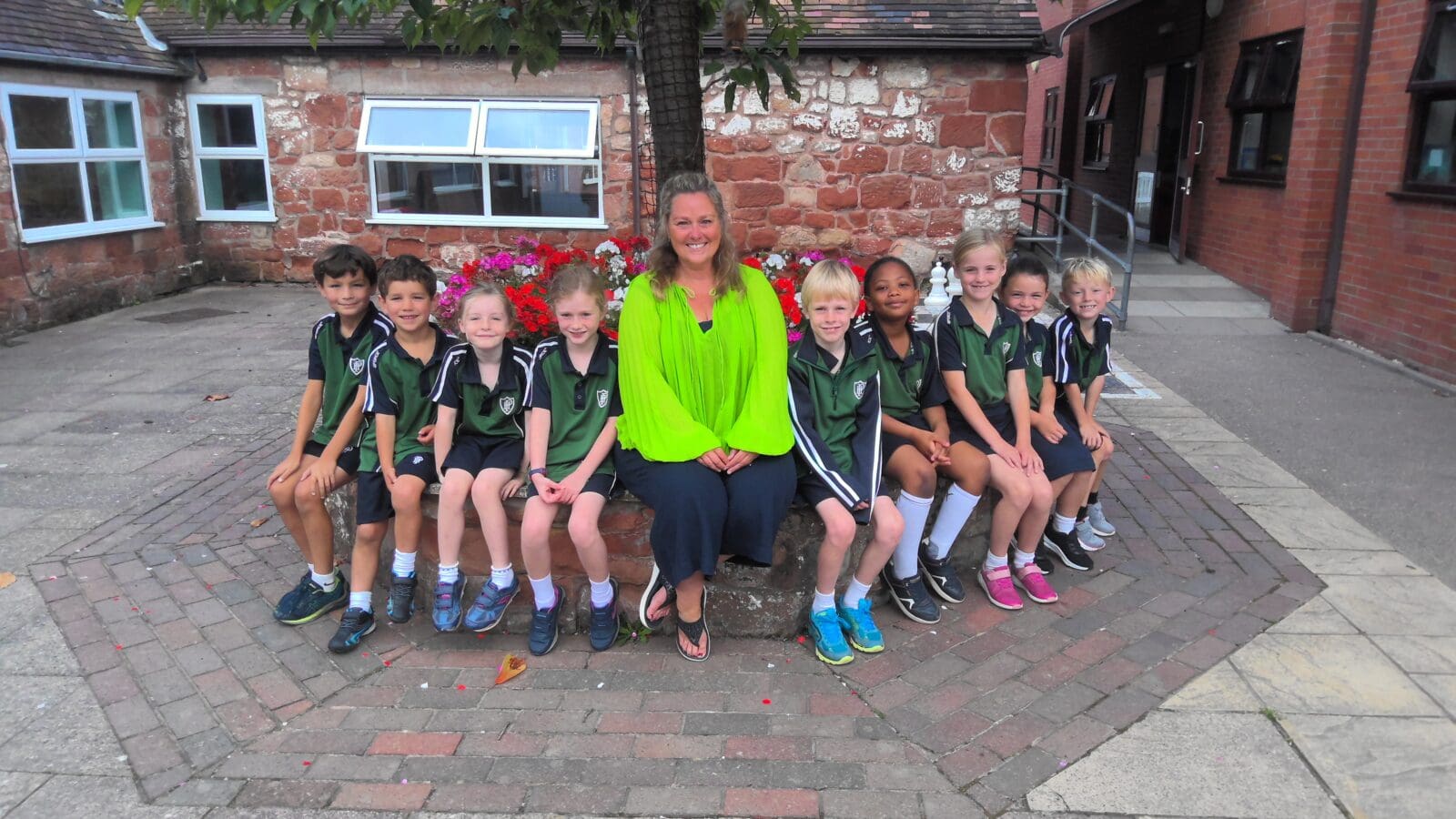 Year 3 children sitting beneath a tree with their teacher