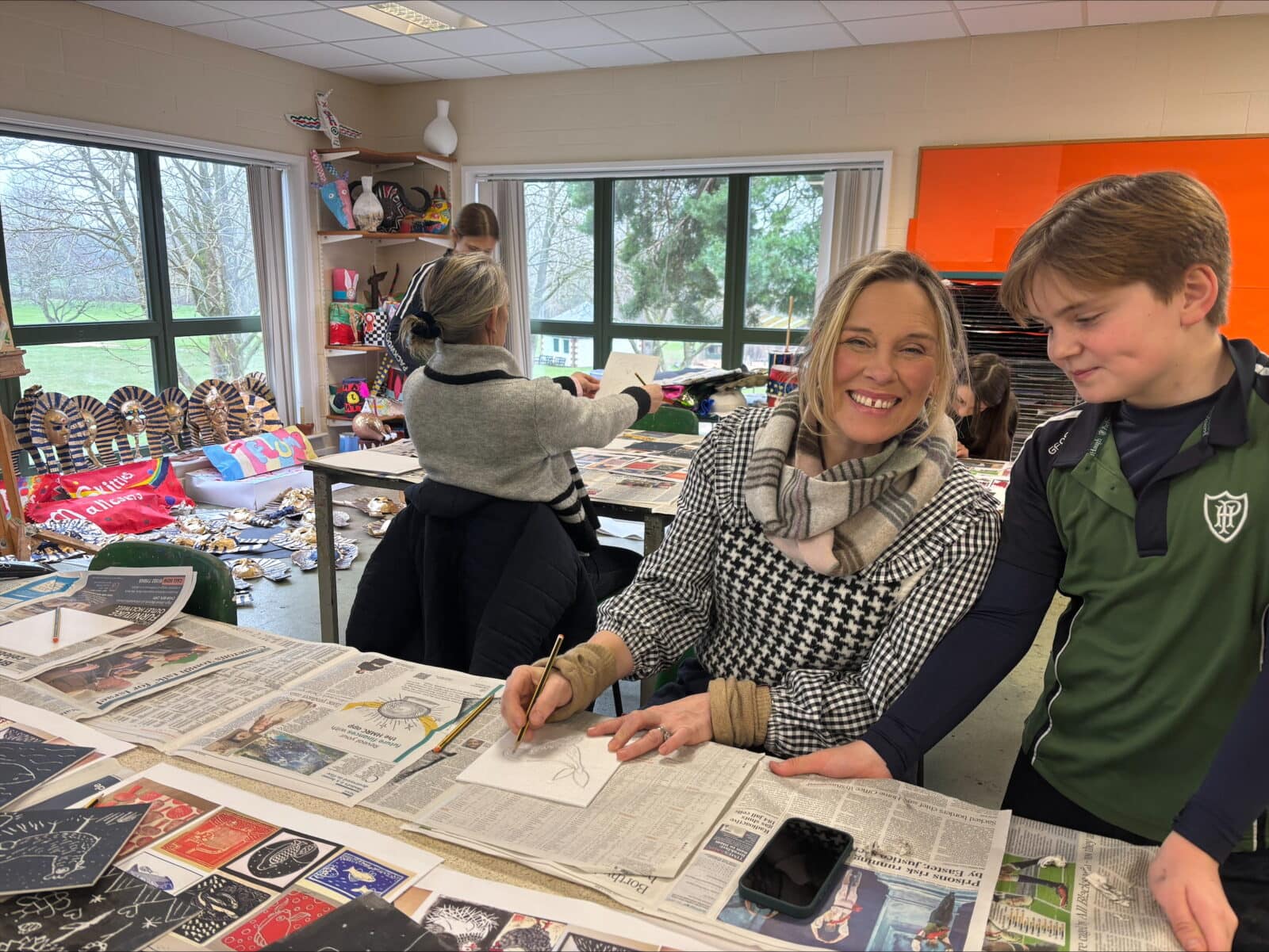 Mother and son in art classroom working on artwork together