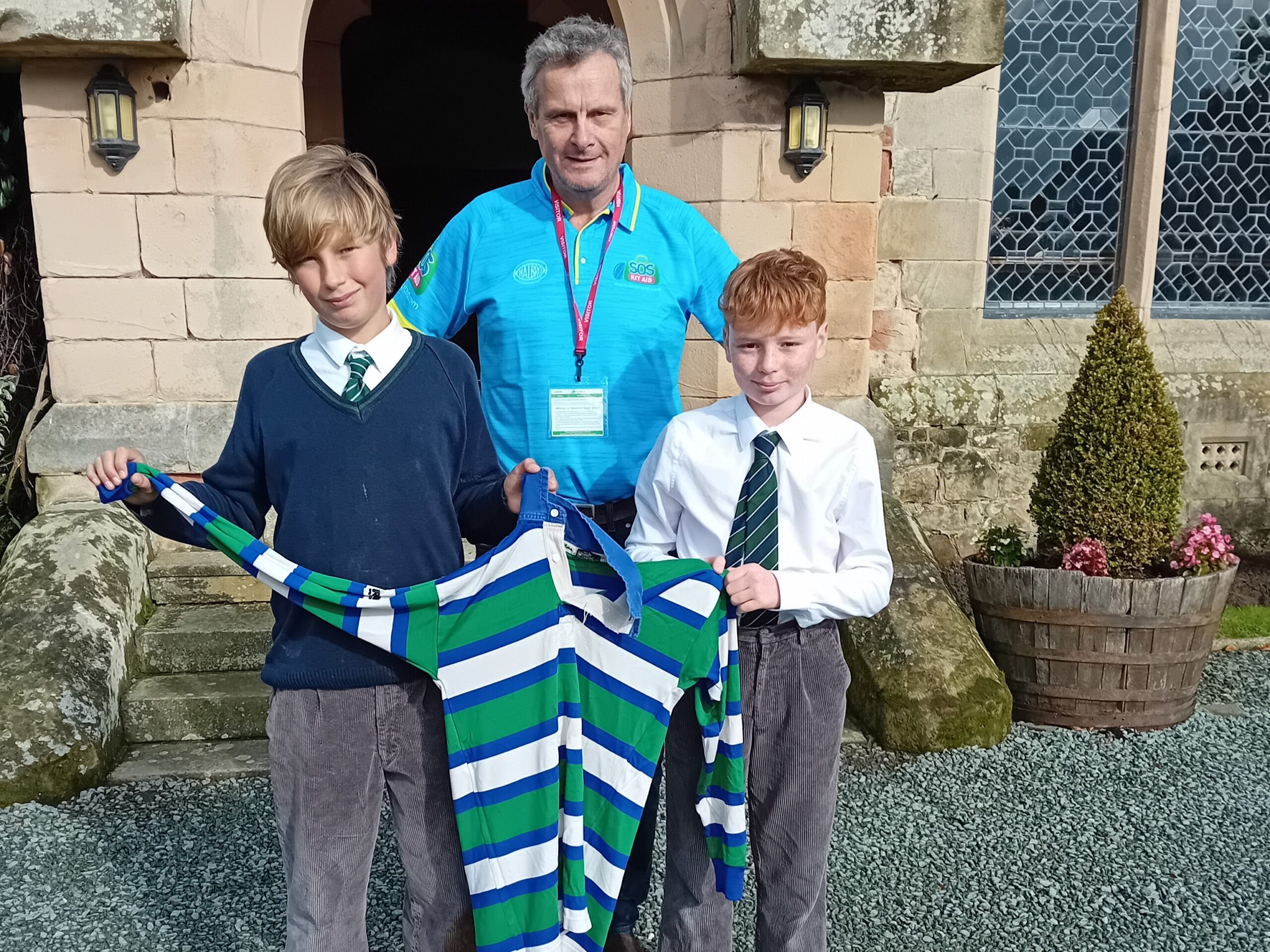 Pupils holding up rugby shirts