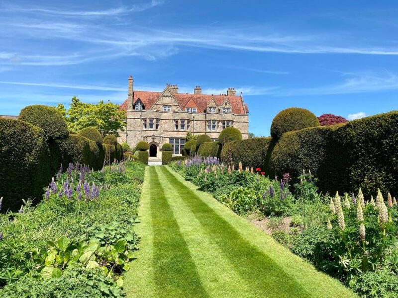 Beautiful garden in front on a traditional school building and blue skies
